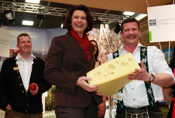 German Agriculture Minister Aigner holds piece of cheese as she visits Internationale Gruene Woche IGW fair in Berlin